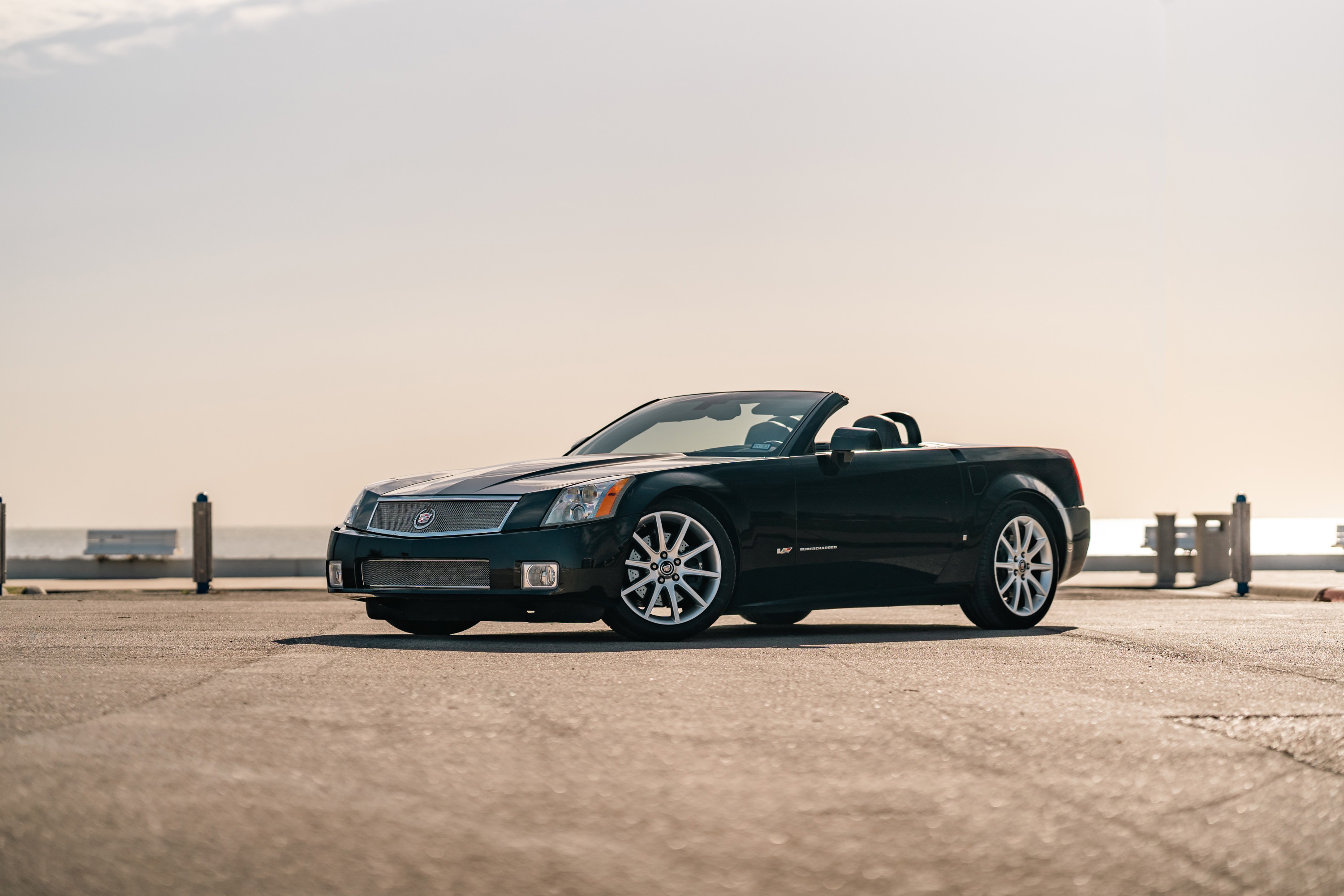 Black Raven 2006 Cadillac XLR-V convertible with chrome rims parked outdoors.