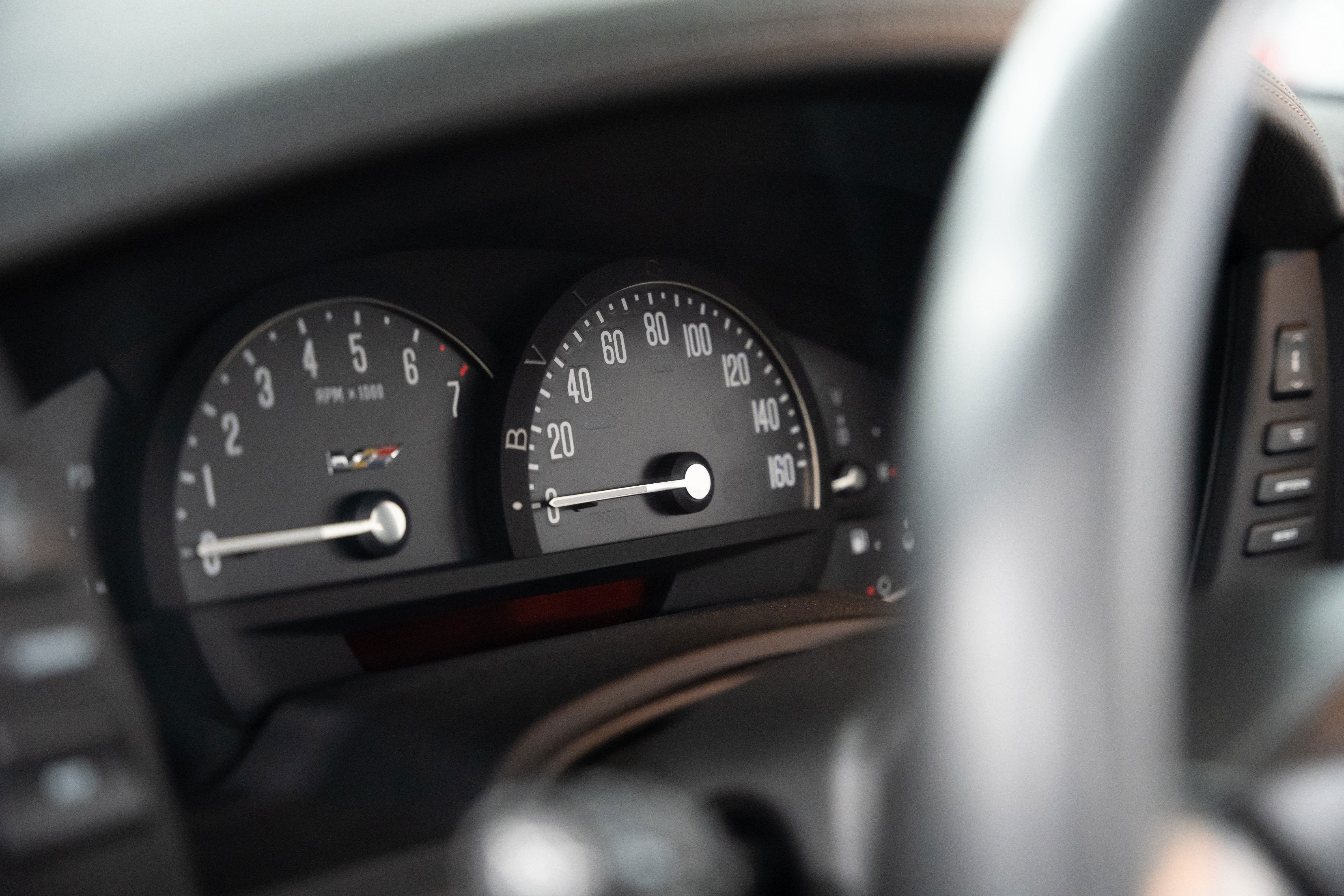 Close-up of the gauge cluster in a black 2006 Cadillac XLR-V, showing the tachometer and speedometer.
