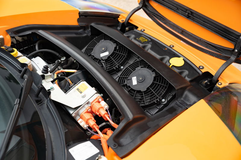 Orange 2010 Tesla Roadster electric drivetrain with cooling fans.