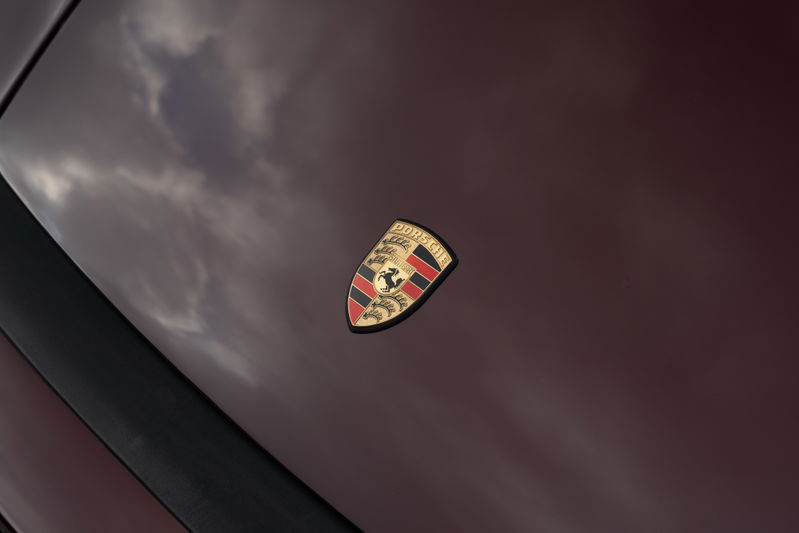 Porsche crest emblem on a ruby red metallic 1983 Porsche 911 SC Cabriolet hood.