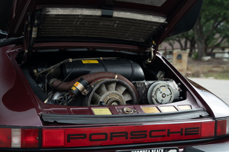 Rear view of a ruby red metallic 1983 Porsche 911SC Cabriolet engine bay.