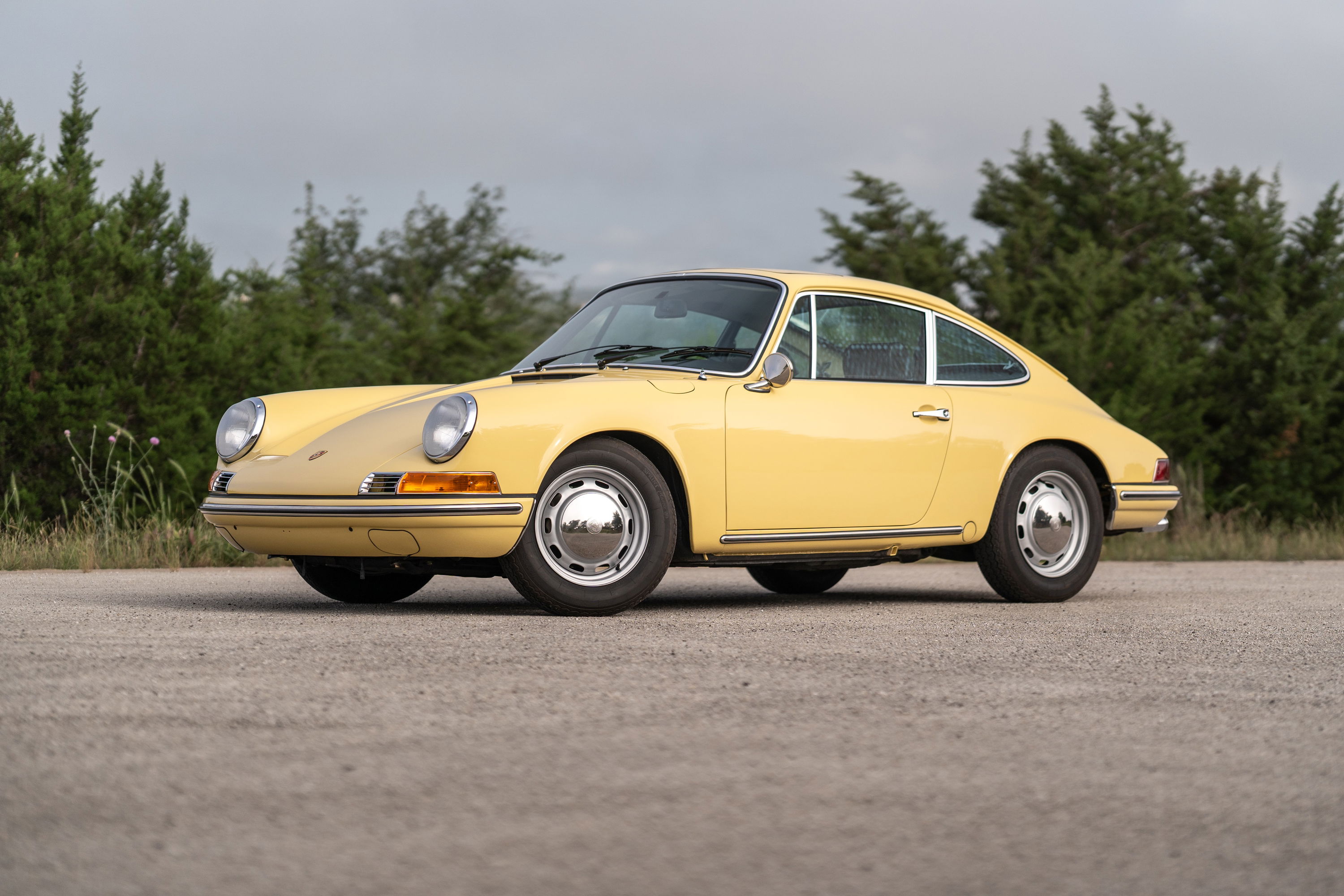A champagne yellow 1969 Porsche 912 Coupe on chrome rims.