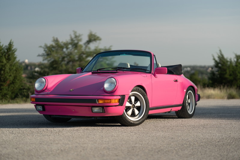 Pink Porsche 911 Carrera convertible with Fuchs rims and black trim.
