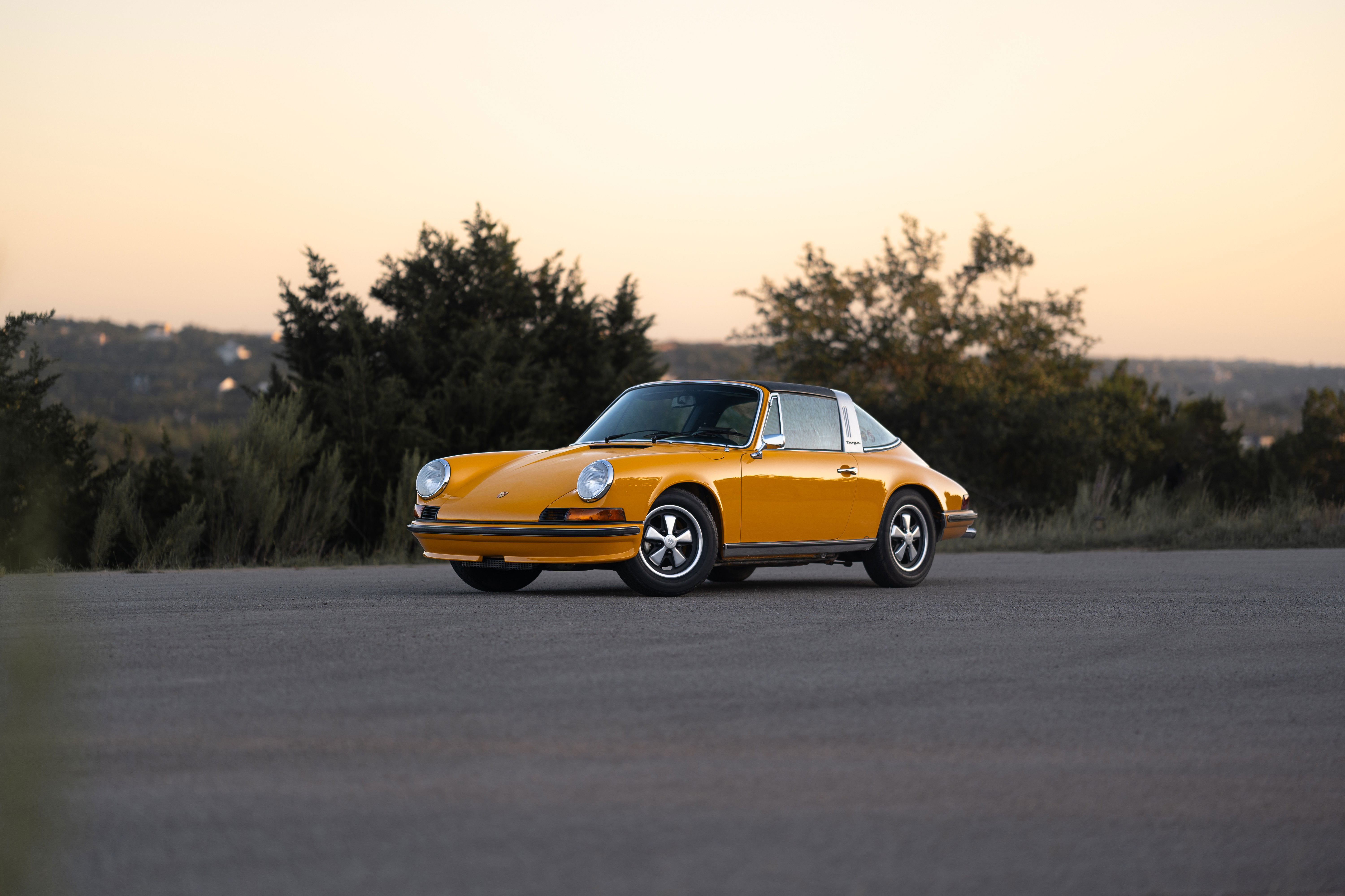 Signal yellow 1973 Porsche 911S Targa with chrome trim and Fuchs rims.