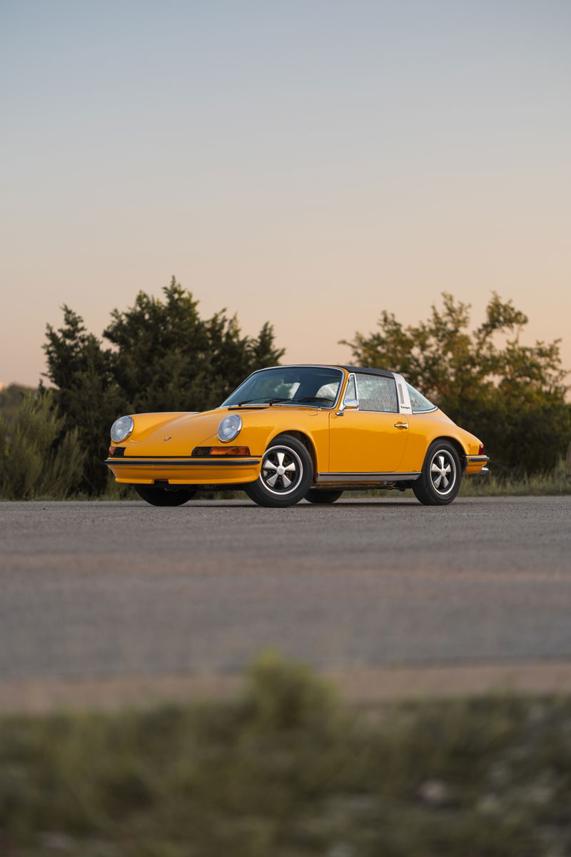 Yellow 1973 Porsche 911S Targa with Fuchs wheels and black Targa top.
