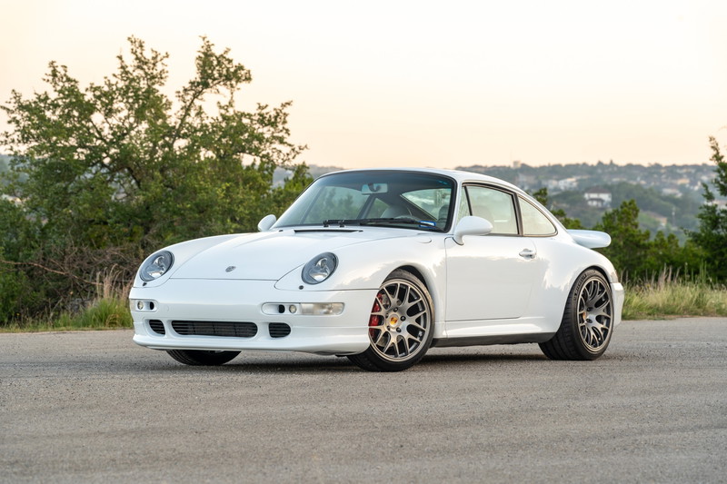 1997 Porsche 993 C4S in Glacier White with silver multi-spoke rims and red brake calipers.