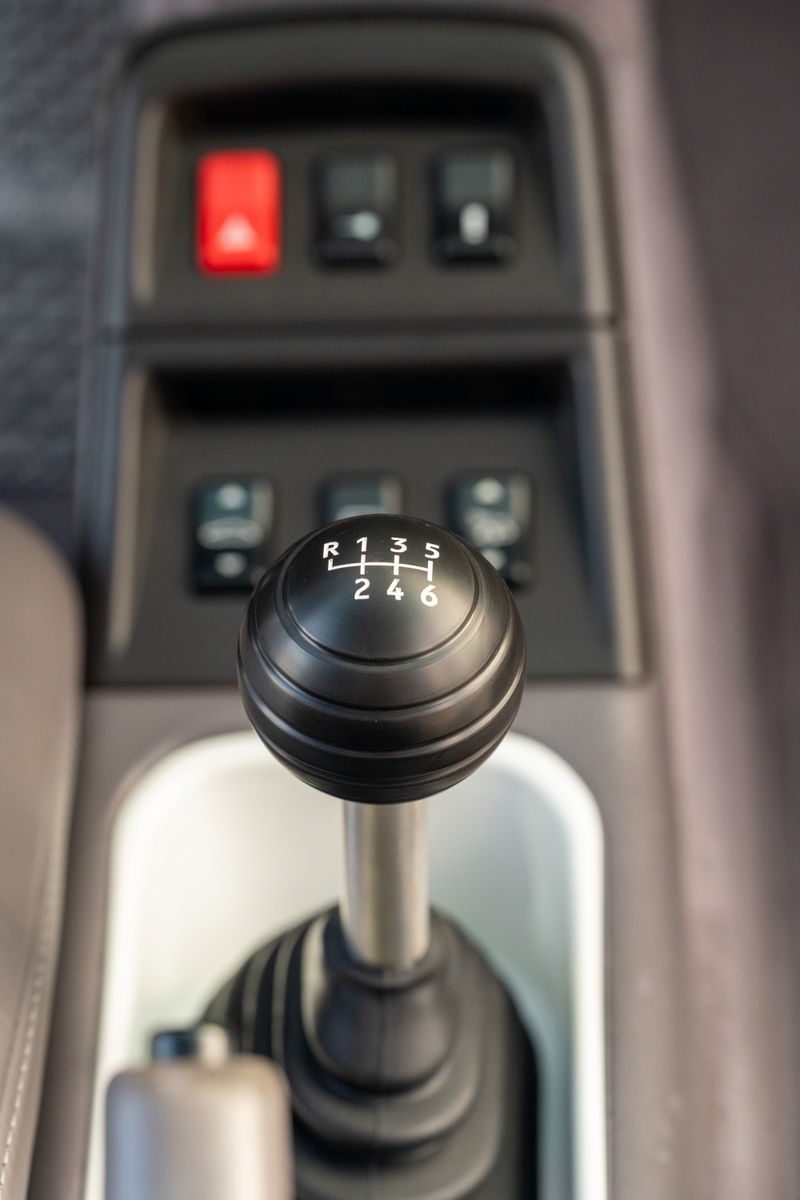 1997 Porsche 993 C4S manual gear shift knob with 6-speed pattern and red hazard switch.