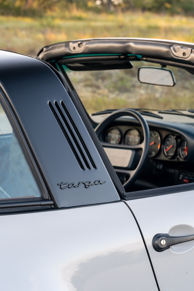 Close-up of a 1987 Porsche 911 Carrera Targa in Marble Grey. The Targa trim and interior are visible.