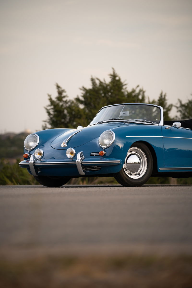 Blue 1960 Porsche 356B Roadster with chrome hubcaps and brightwork trim.