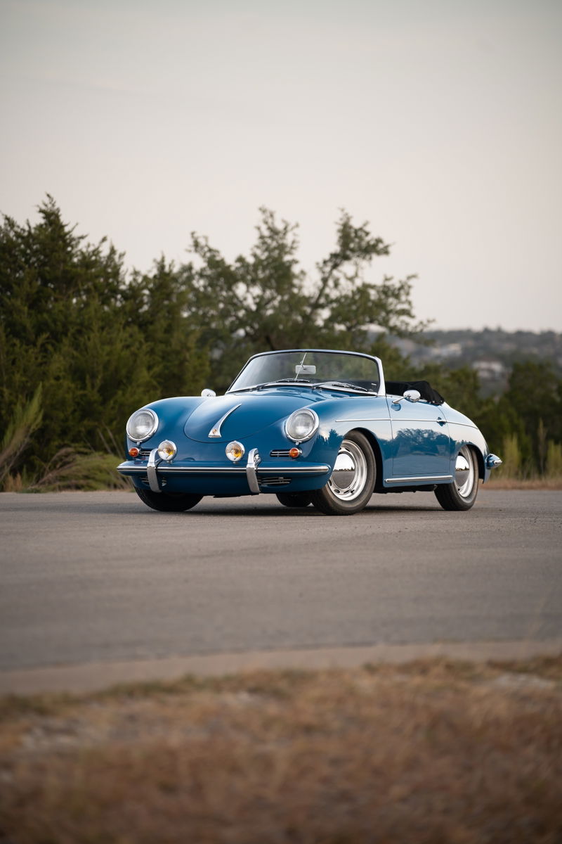 A royal blue 1960 Porsche 356B Roadster convertible with chrome trim and wire wheels.