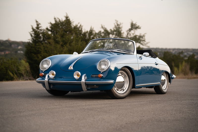 Blue 1960 Porsche 356B Roadster with chrome hubcaps on steel rims.