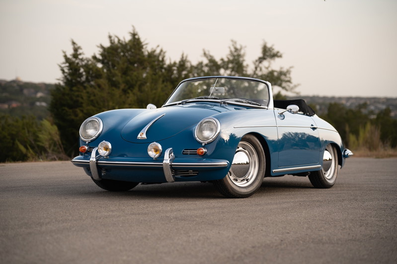 Blue 1960 Porsche 356B Roadster with chrome hubcaps on steel rims.