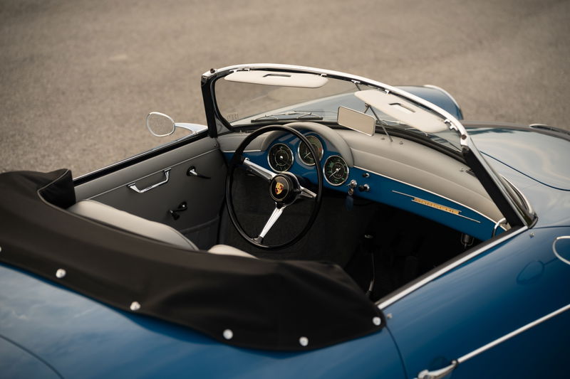 Close-up interior shot of a royal blue 1960 Porsche 356B Roadster dashboard and driver's side.