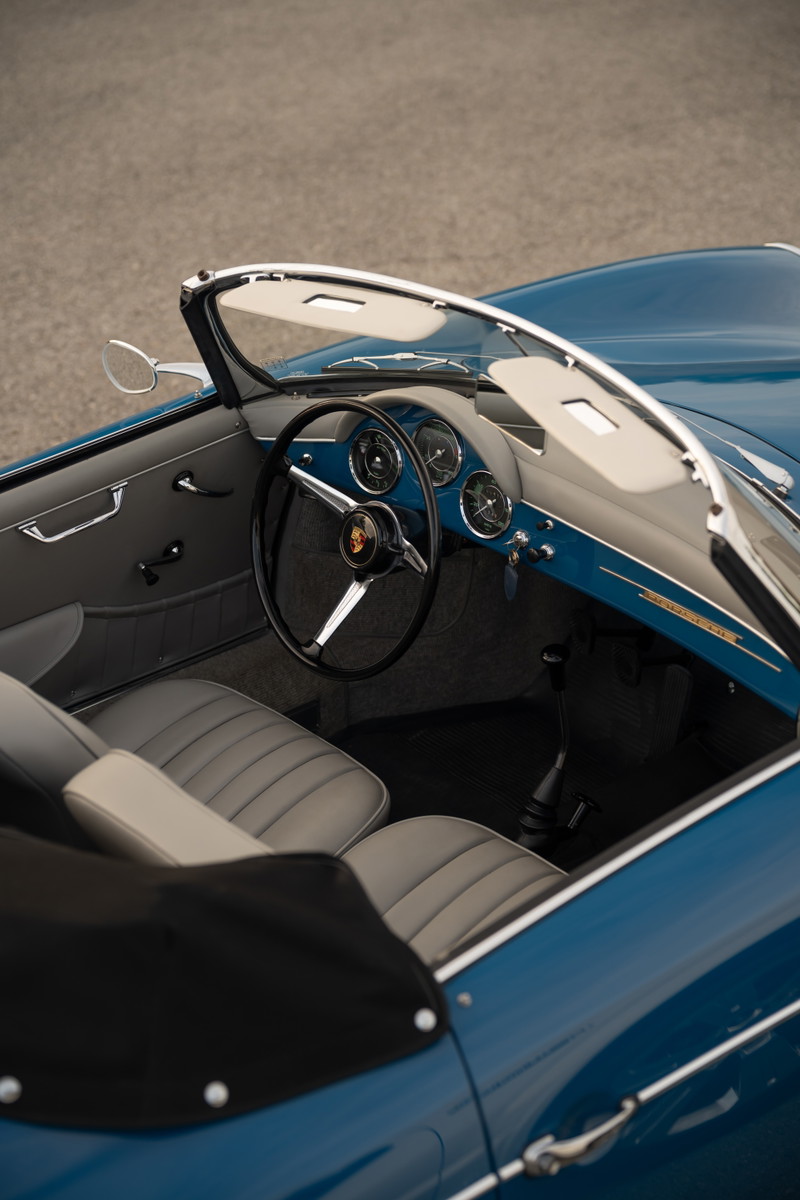Interior view of a royal blue 1960 Porsche 356B Roadster, featuring classic gauges and grey leather seats.