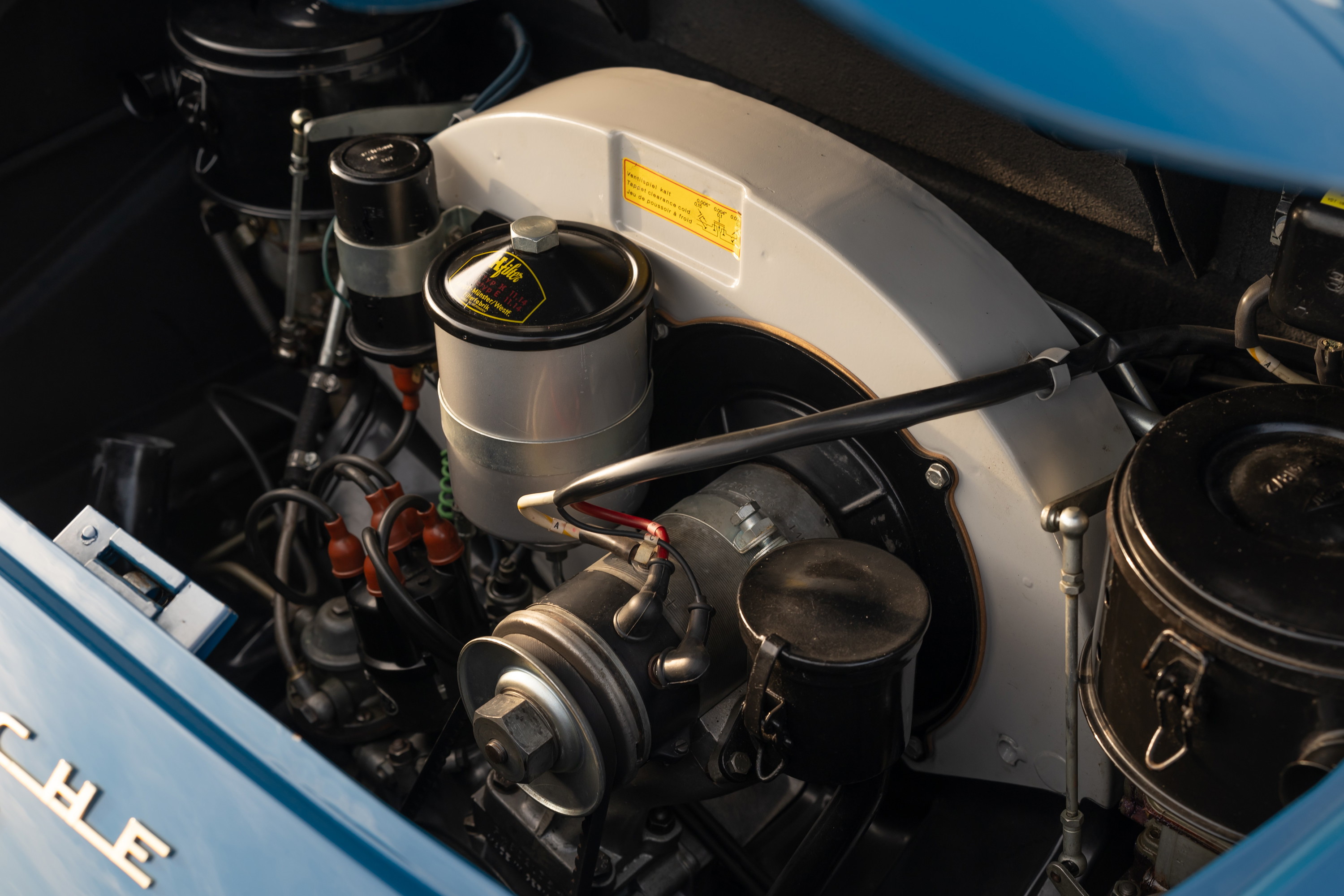 Close-up of a royal blue 1960 Porsche 356B engine bay, showing the fan shroud and cooling system.