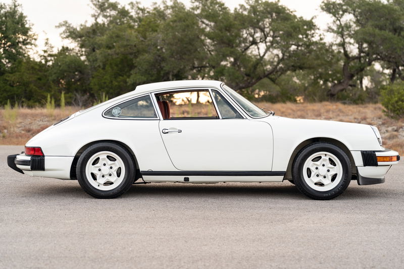White 1974 Porsche 911 coupe with Fuchs-style rims and black trim.