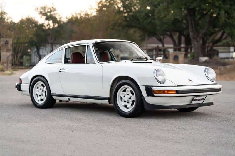 1974 white Porsche 911 coupe with classic Fuchs rims and black trim.