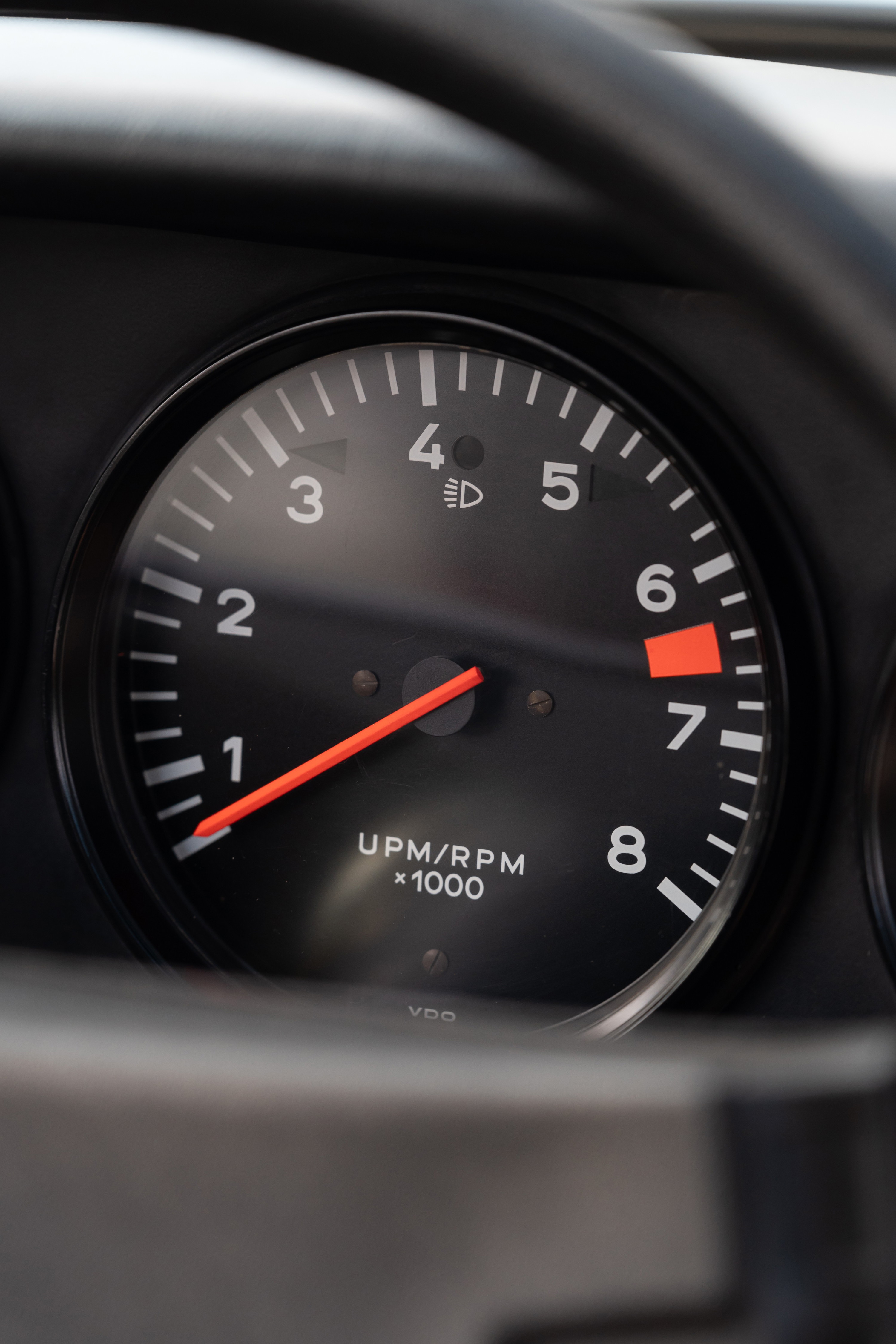 1974 Porsche 911 Coupe tachometer shows 7000 RPM redline, VDO gauge.