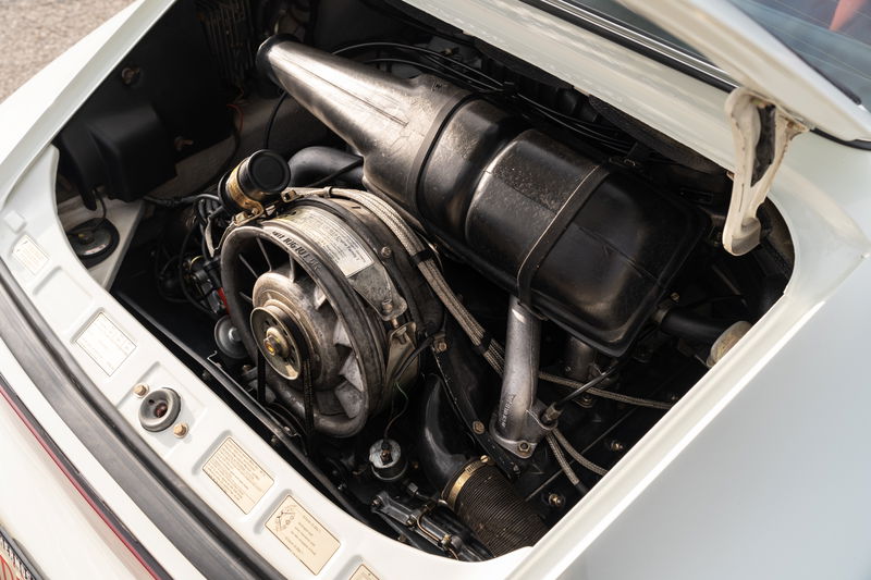 Close-up of a 1974 Porsche 911 coupe's air-cooled flat-six engine.