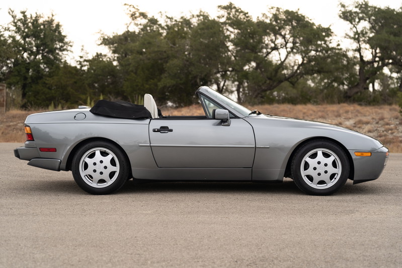 Silver 1990 Porsche 944 S2 Cabriolet with teardrop rims and black convertible top.