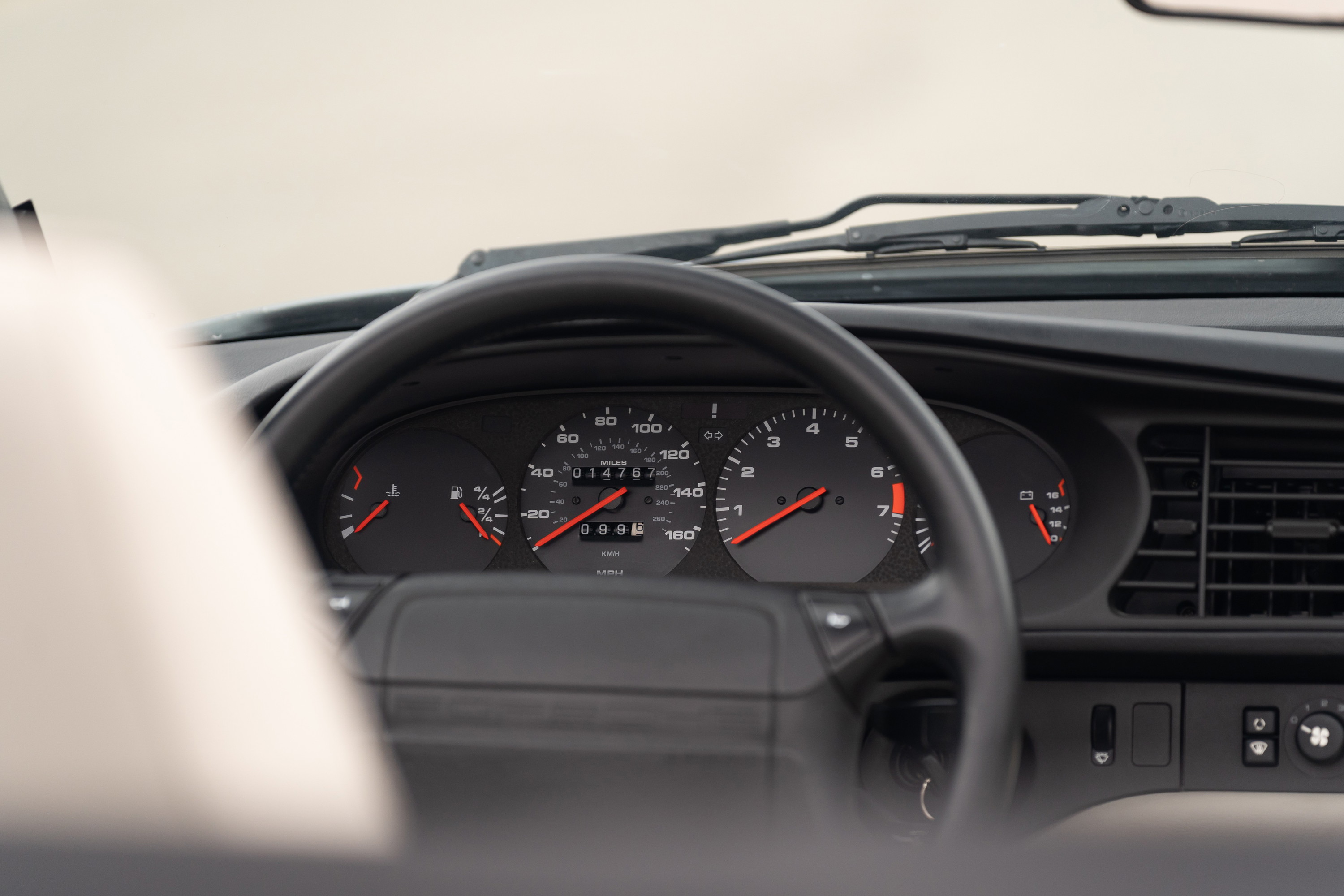 1990 Porsche 944 S2 Cabriolet dashboard. Black interior, analog gauges, and steering wheel.