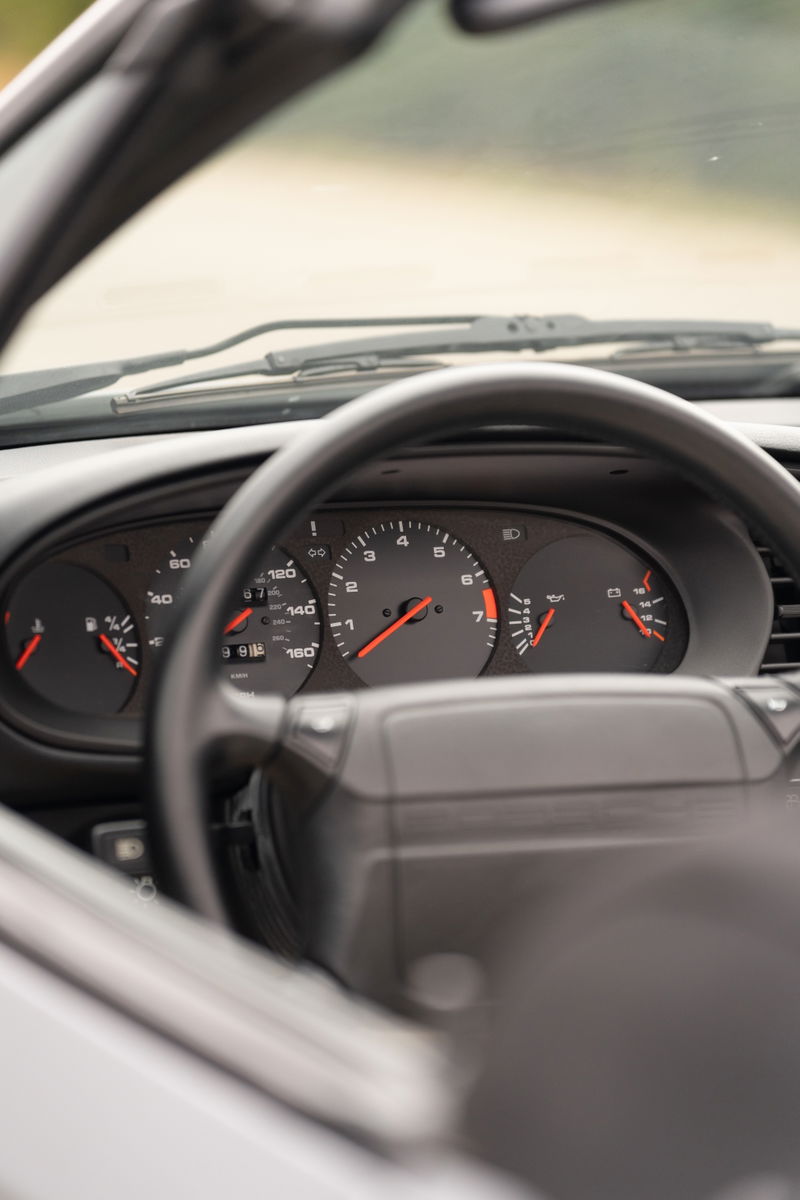 Interior of a 1990 Porsche 944 S2 Cabriolet in Titanium Metallic, featuring the instrument cluster and steering wheel.