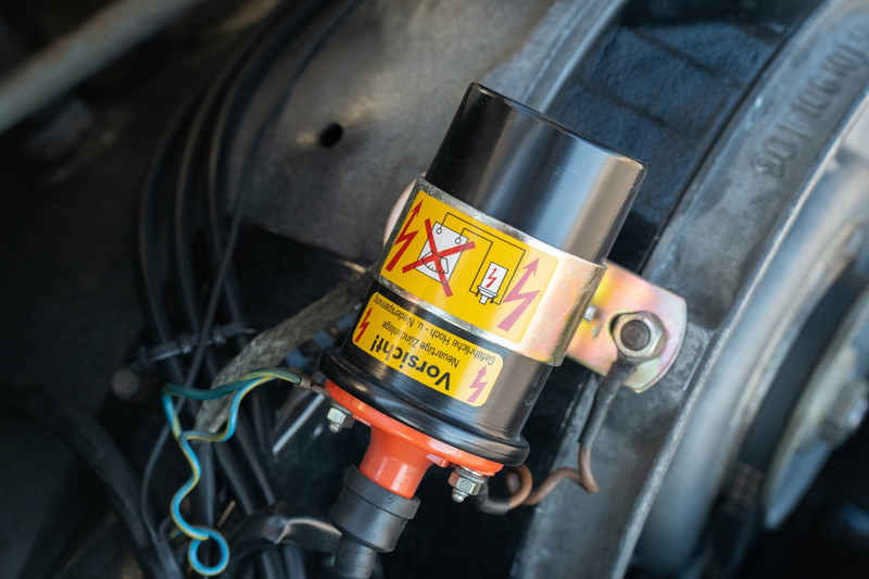 1970 Porsche 911T coupe ignition coil with warning labels and wiring.