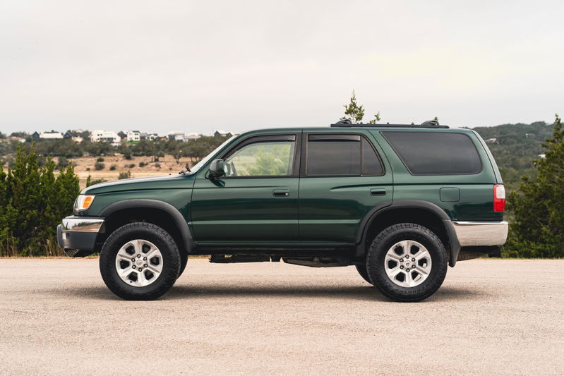Green 2000 Toyota 4Runner with silver rims, dark tinted windows, and chrome trim accents.