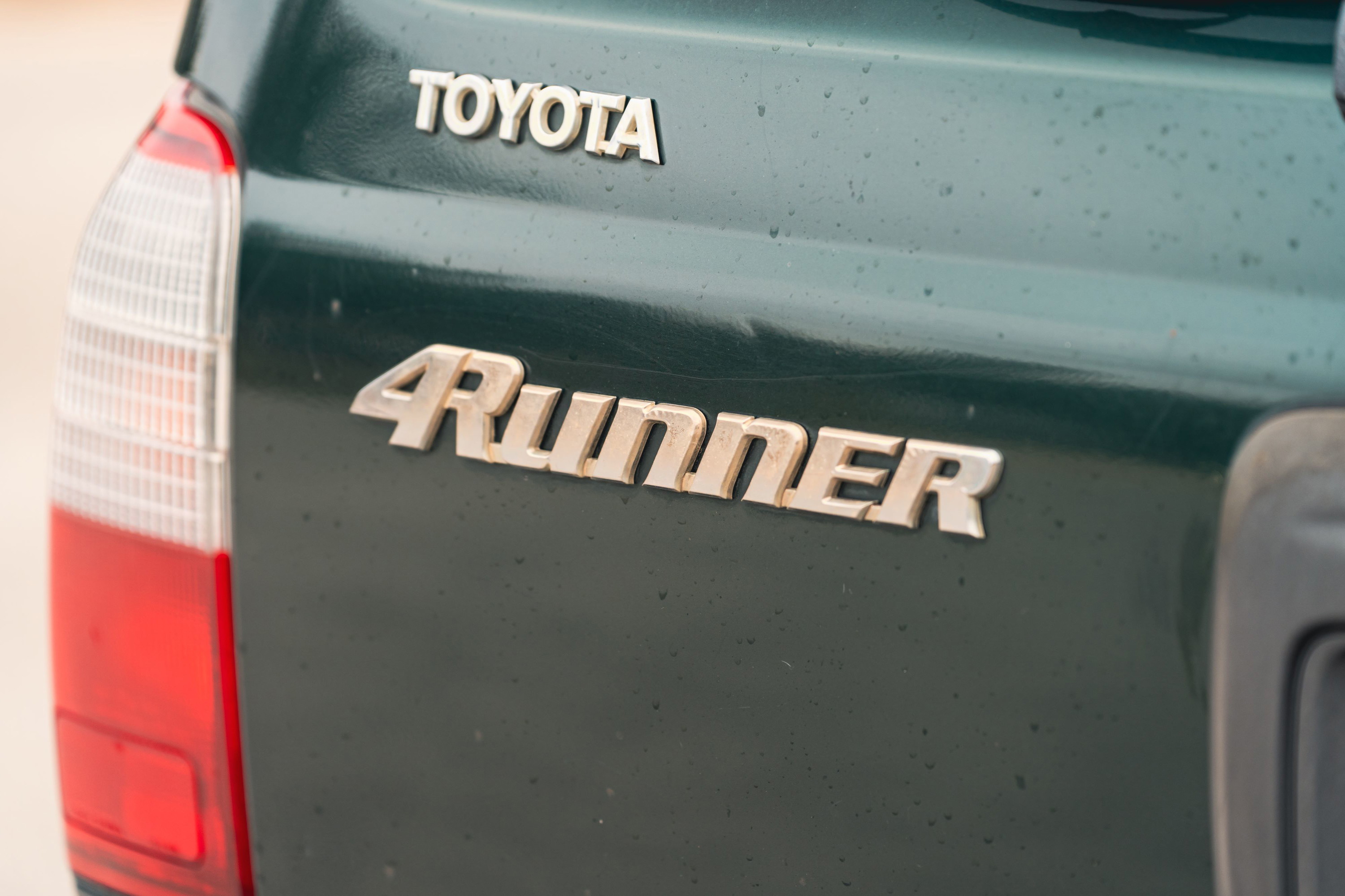 Close-up of a green 2000 Toyota 4Runner's rear badging.