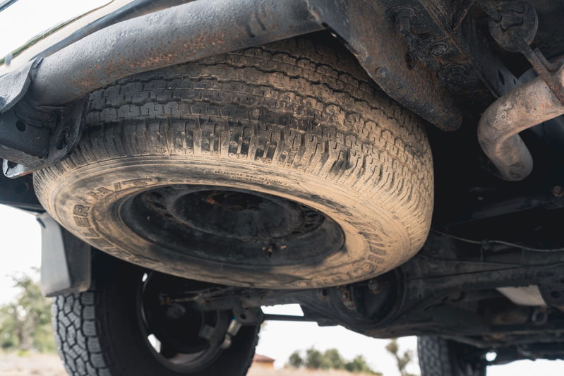 Underbody of a 2000 Toyota 4Runner with mounted spare tire and exhaust.