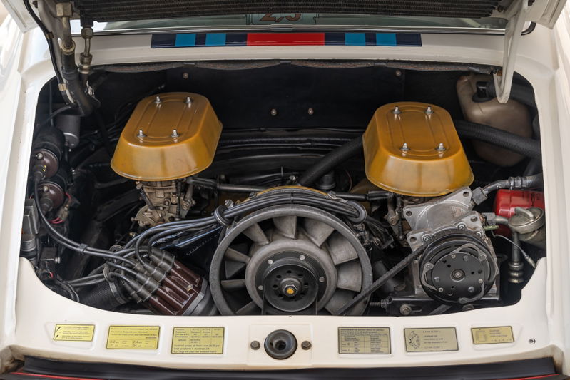 Porsche 911 engine bay with twin Weber carburetors and gold airbox lids.