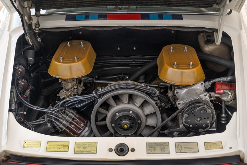 Porsche 911 engine bay with twin Weber carburetors and gold airbox lids.