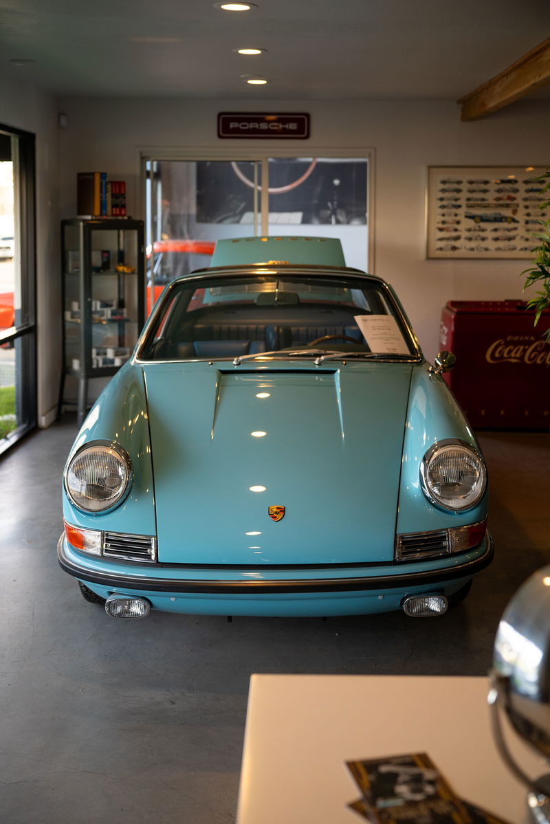 Front view of a light blue 1970s Porsche 911 Targa with chrome trim and bumper guards.