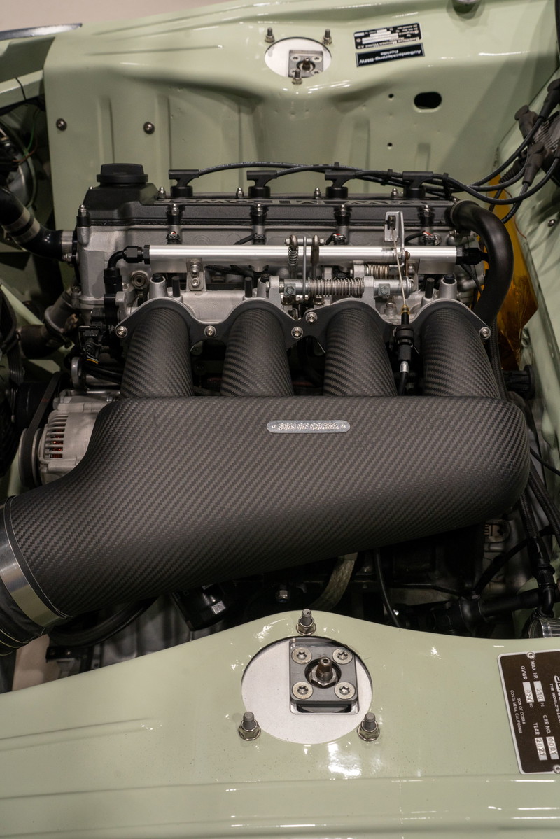 Custom BMW M3 engine bay with carbon fiber intake manifold.