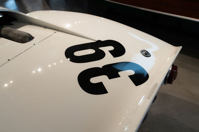 White classic race car with black "36" livery and chrome trim details at a car show.