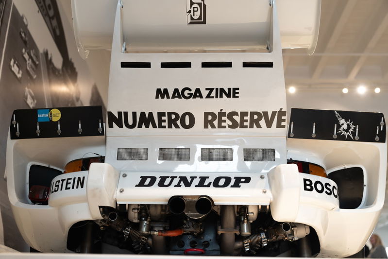Rear view of a white Porsche race car with Dunlop tires and sponsor livery at the LIT Show LA.