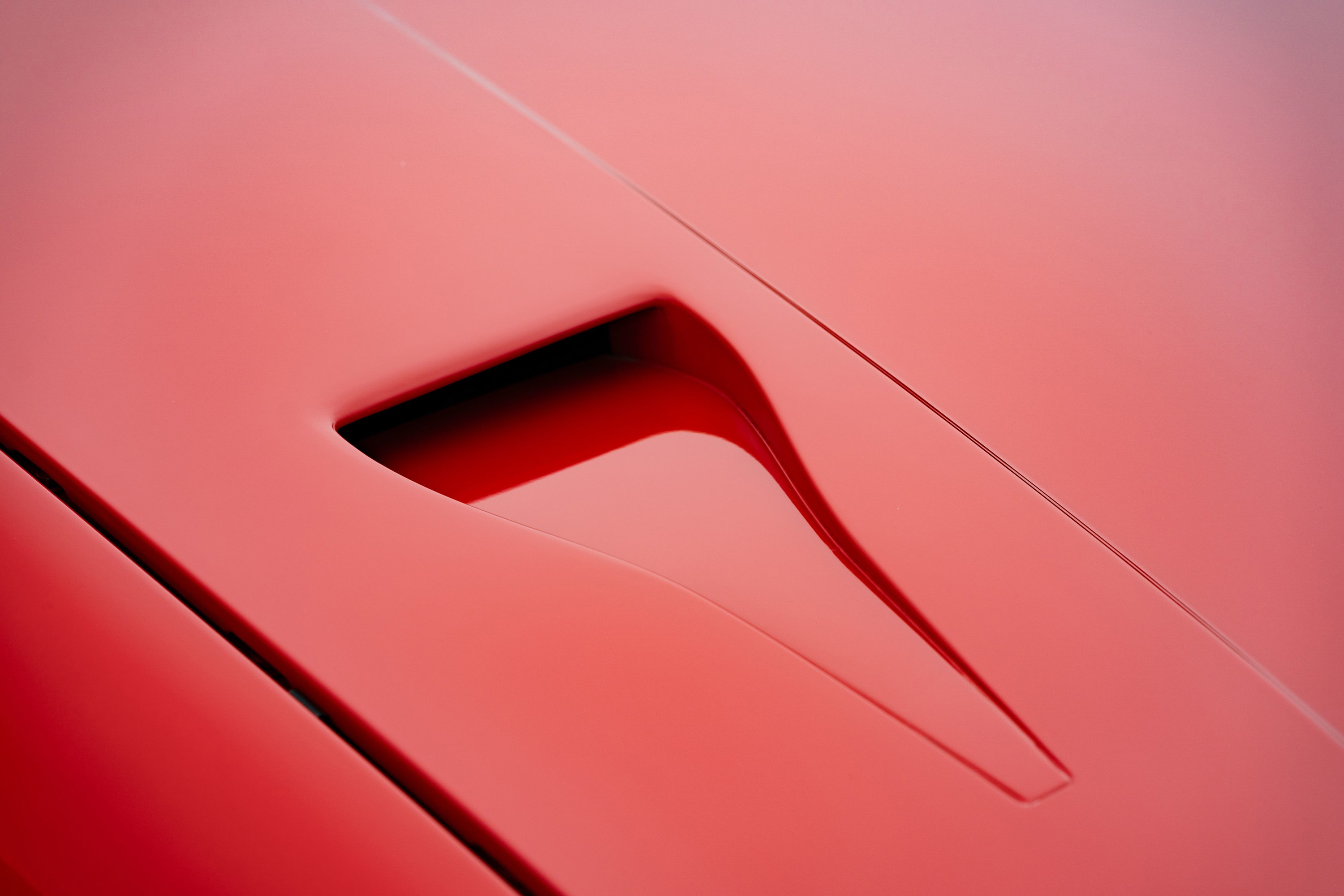 Close up of a red 1981 Porsche 924 Turbo hood vent.
