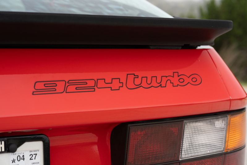 Rear view of a Guards Red 1981 Porsche 924 Turbo with black badging and a black rear spoiler.