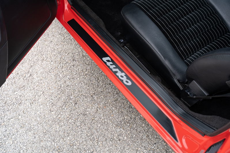 Red 1981 Porsche 924 Turbo door sill trim with "Turbo" lettering.