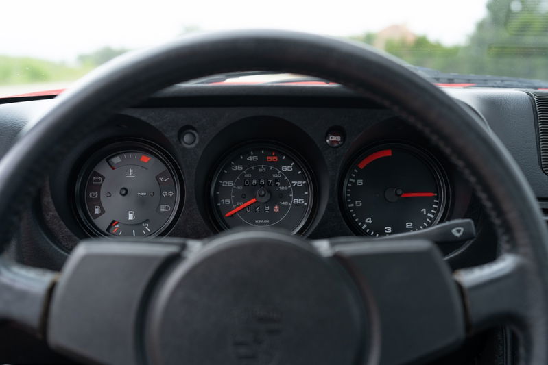 Interior of a Guards Red 1981 Porsche 924 Turbo, showing the dashboard gauges and steering wheel.