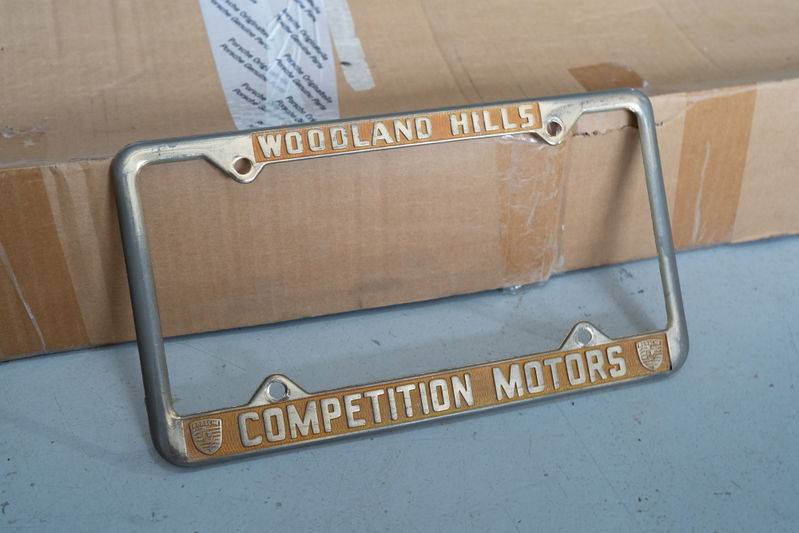 Porsche license plate frame from Competition Motors Woodland Hills, with gold trim and crests.
