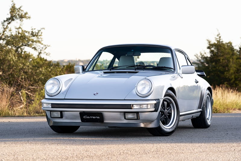 Silver metallic 1987 Porsche 911 Carrera G50 with black Fuchs rims and black trim.