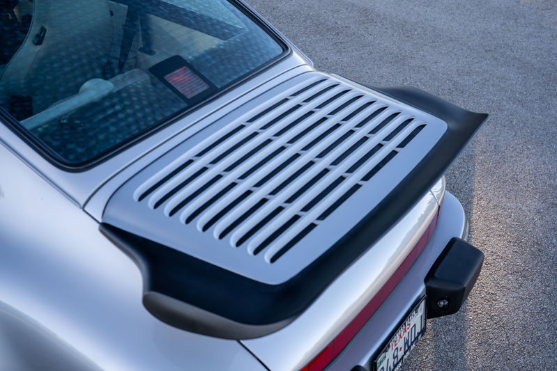 Close-up of the silver 1987 Porsche 911 Carrera's rear decklid and spoiler.