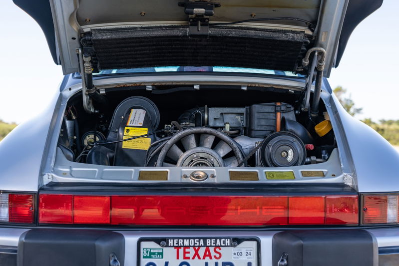 Silver 1987 Porsche 911 Carrera G50 engine bay with exposed flat-six engine, fan, and air intake.