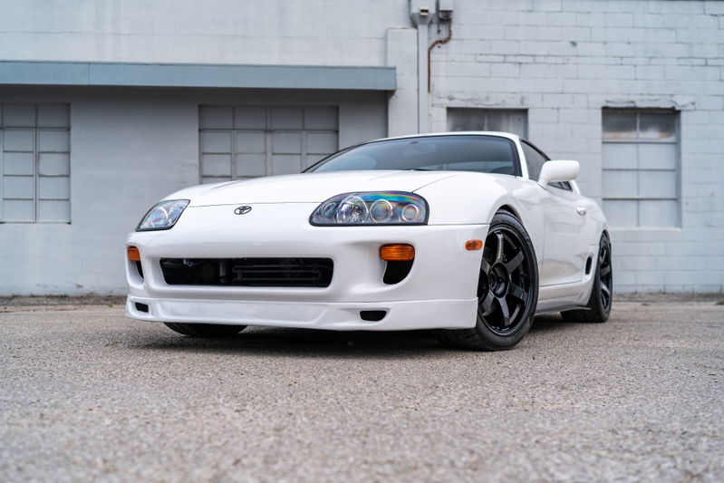White 1994 Toyota Supra with black rims parked outdoors.