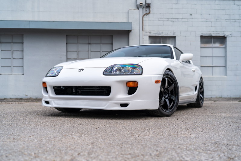 White 1994 Toyota Supra with black rims parked outdoors.
