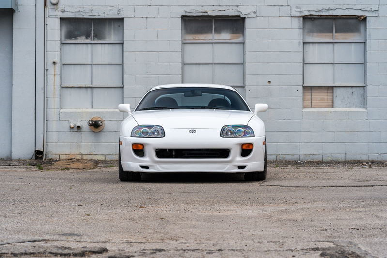 White 1994 Toyota Supra, front view, showing headlights, bumper, and hood.