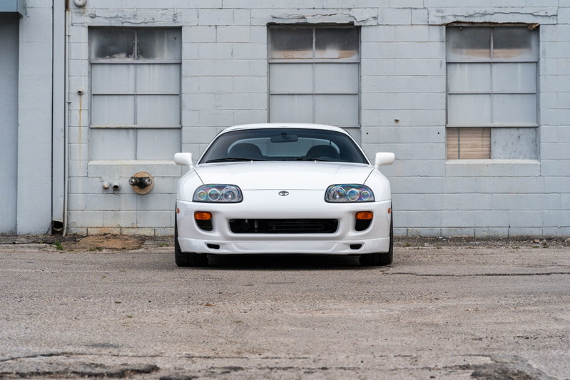 White 1994 Toyota Supra, front view, showing headlights, bumper, and hood.