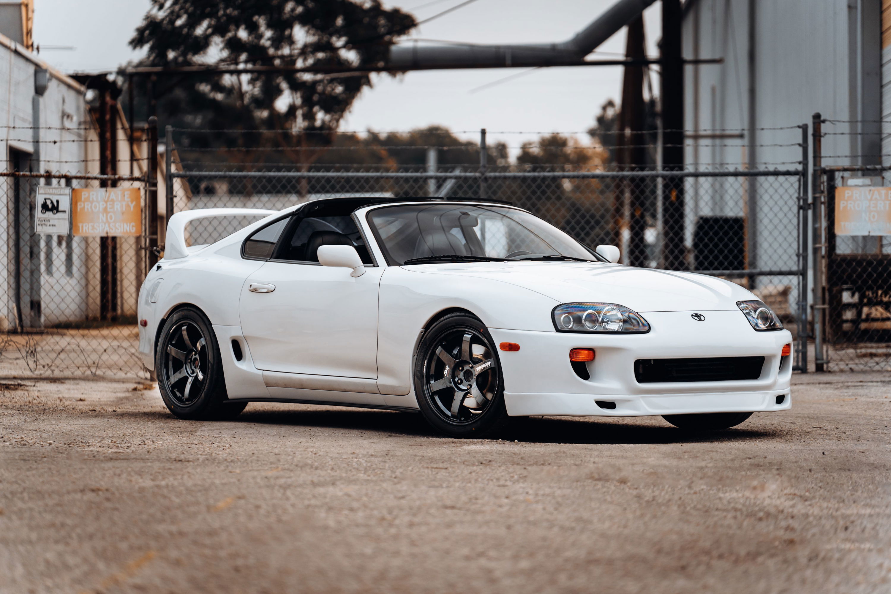 White 1994 Toyota Supra with aftermarket rims and a Targa top.