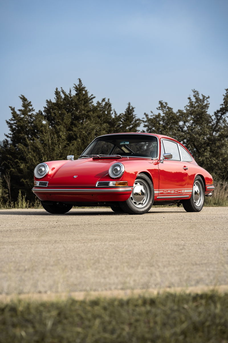 Front 3/4 view of a red 1967 Porsche 912 coupe with chrome trim and Fuchs wheels.